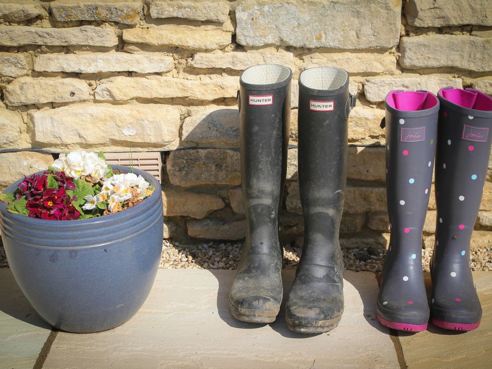 Rubber boots and a flower pot on gravel at Stanbridge Cottage in Malmesbury