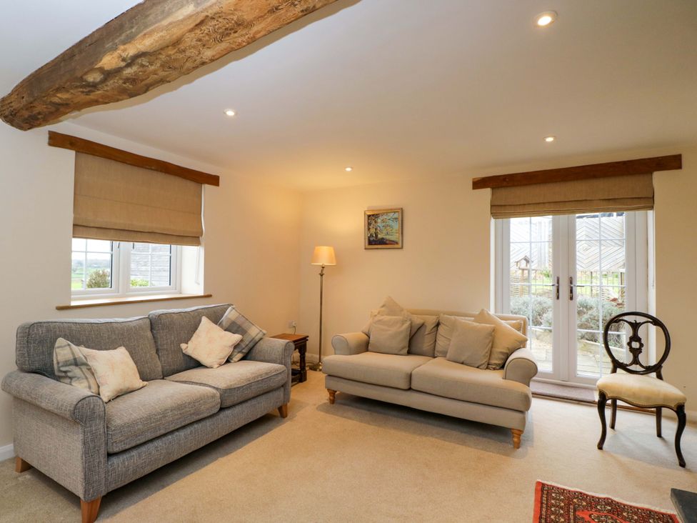 A living room with sofas and a table at Stanbridge Cottage Malmesbury