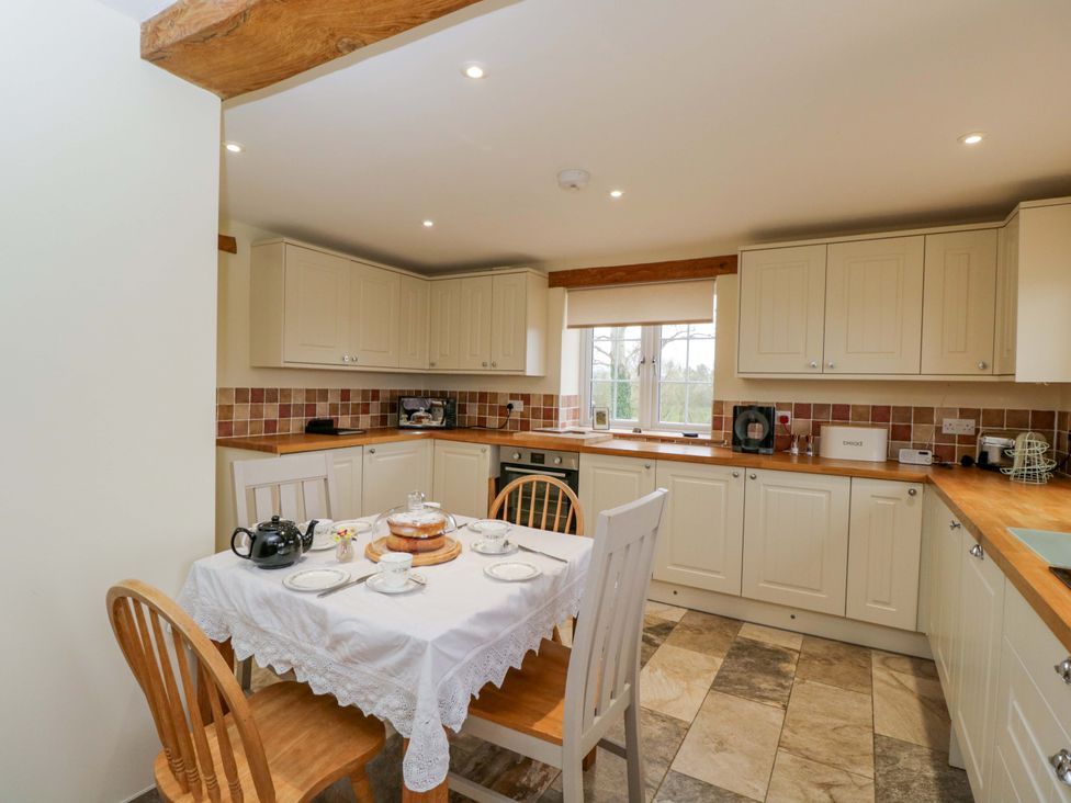 A kitchen with a table and chairs at Stanbridge Cottage in Malmesbury