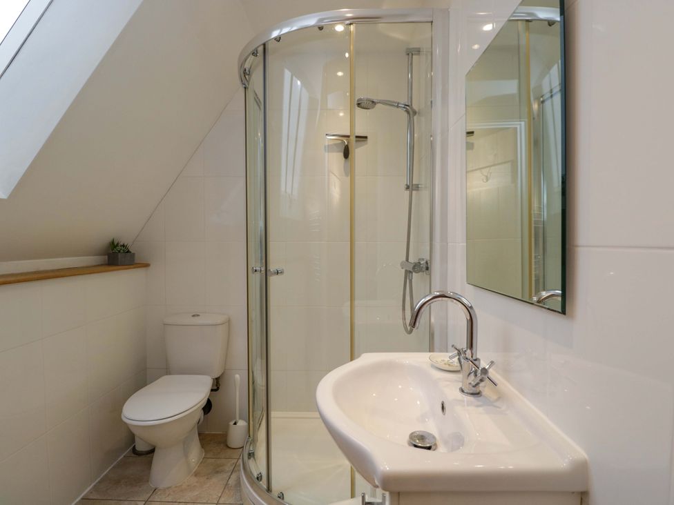A bathroom with a shower, toilet, and sink at Stanbridge Cottage in Malmesbury