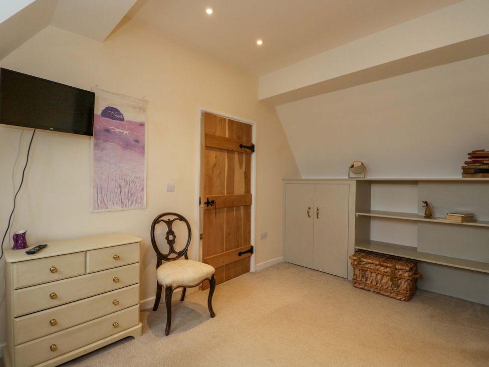A bedroom with a television and a chest of drawers at Stanbridge Cottage in Malmesbury