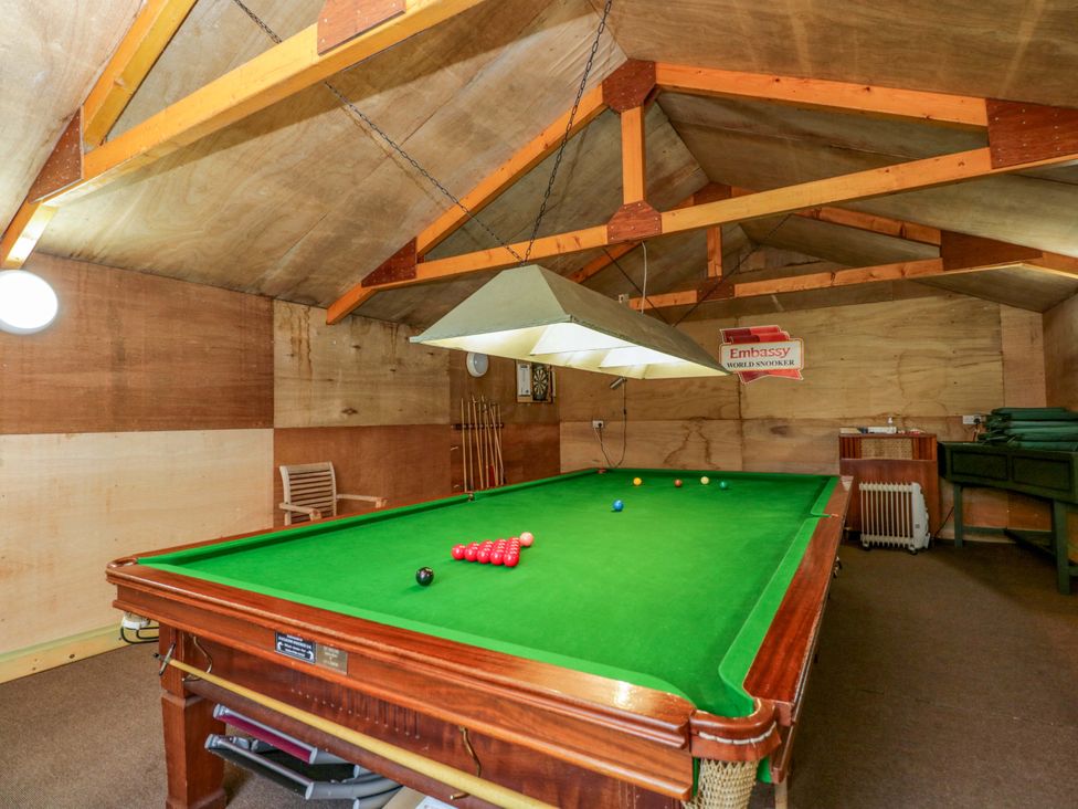 A games room with a snooker table and cues at Stanbridge Cottage in Malmesbury