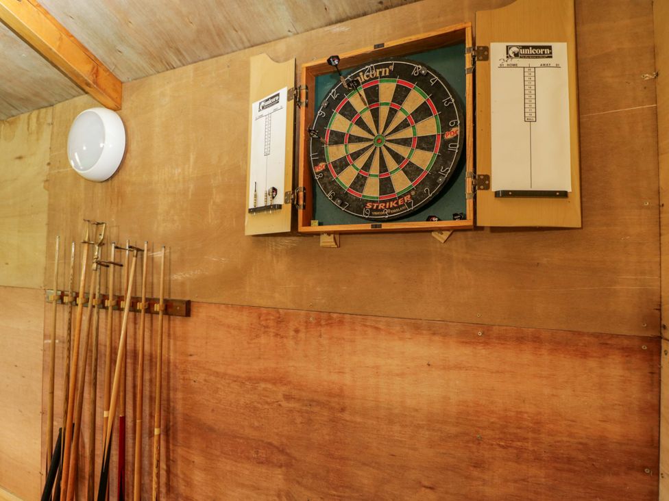 A games room with a dartboard and cue sticks at Stanbridge Cottage Malmesbury