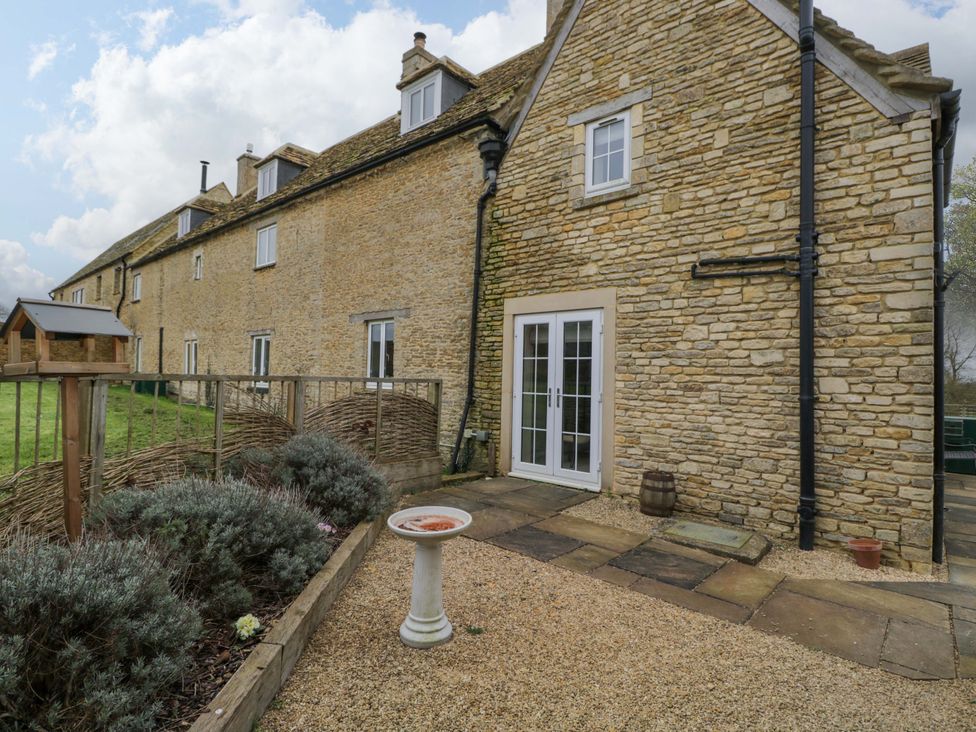 An outdoor area with a stone building and gravel at Stanbridge Cottage in Malmesbury