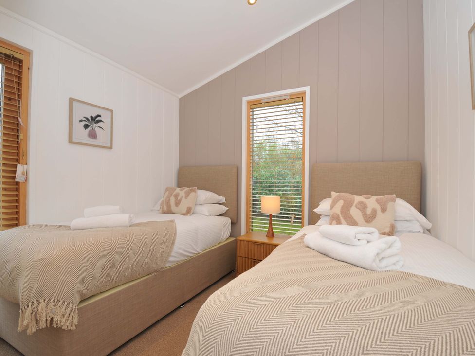 A bedroom with two single beds and a bedside table at 4 Southern Place in Dobwalls