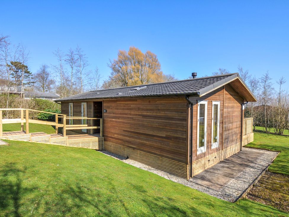 A wooden house with a deck and grass at 4 Southern Place in Dobwalls