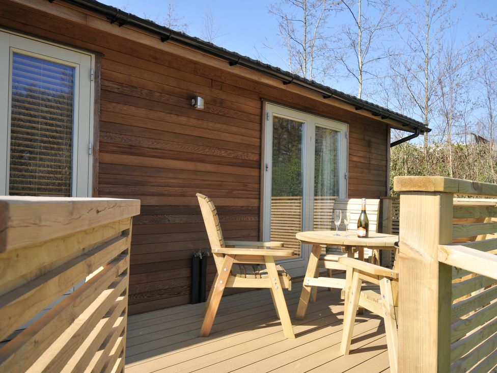 A wooden deck with table and chairs at 4 Southern Place in Dobwalls