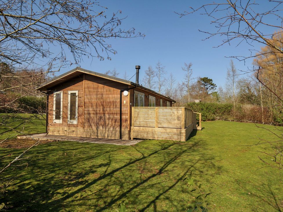 A wooden house with a deck and yard at 4 Southern Place in Dobwalls