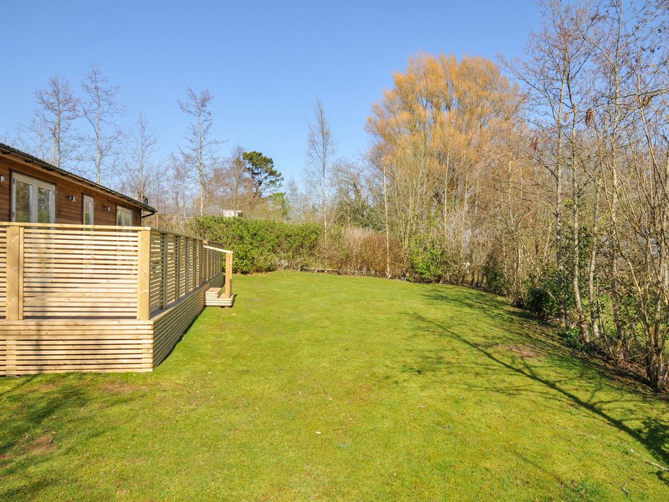 A garden with a deck and trees at 4 Southern Place in Dobwalls