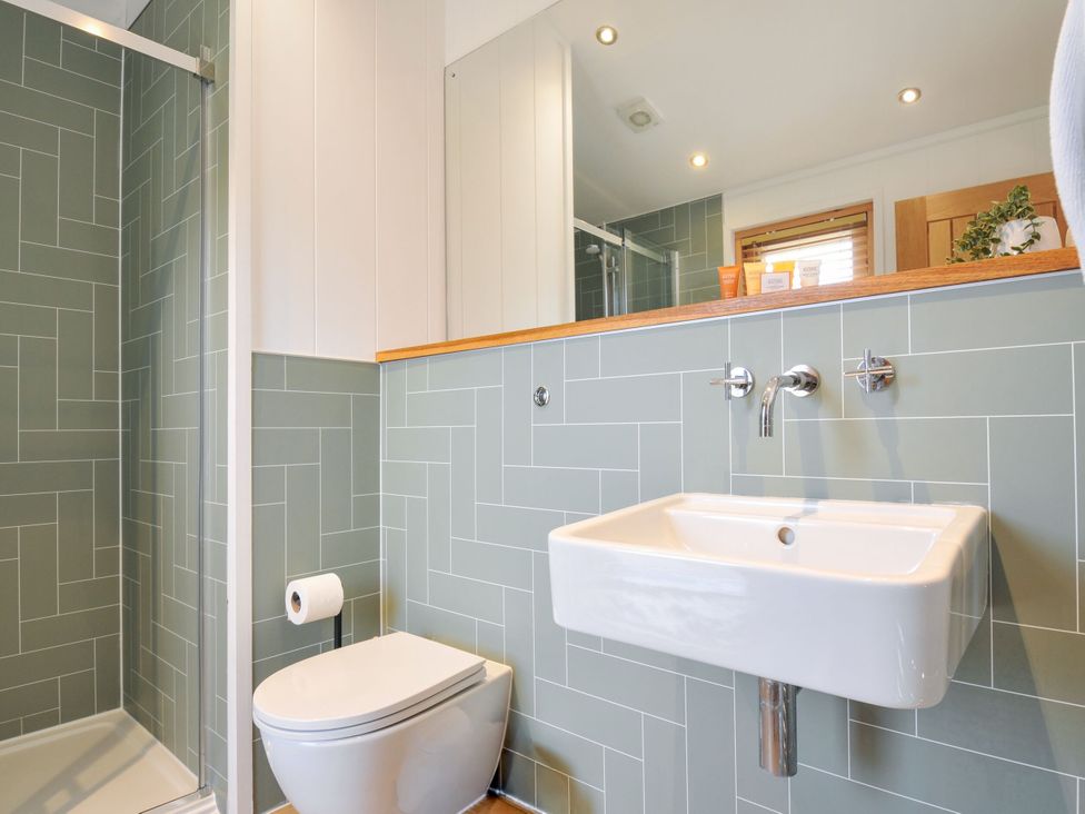 A bathroom with a shower, toilet, and sink at 4 Southern Place in Dobwalls