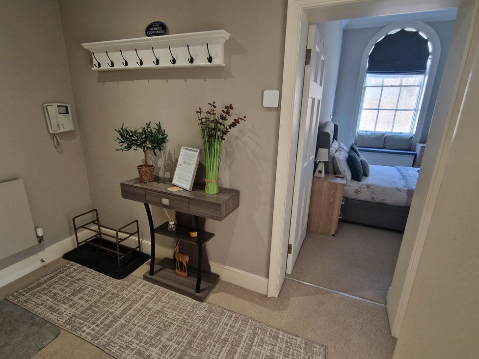A hallway with coat hooks and a console table at Flat 3 in Ross-on-Wye