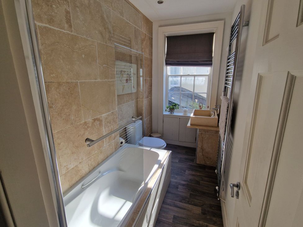 A bathroom with a bathtub, toilet, and sink at Flat 3 in Ross-on-Wye