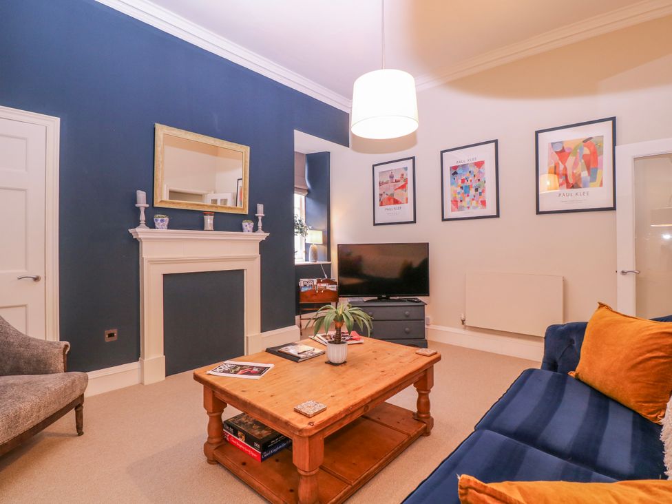 A living room with a coffee table and television at Stylish Town Apartment in Ross-On-Wye