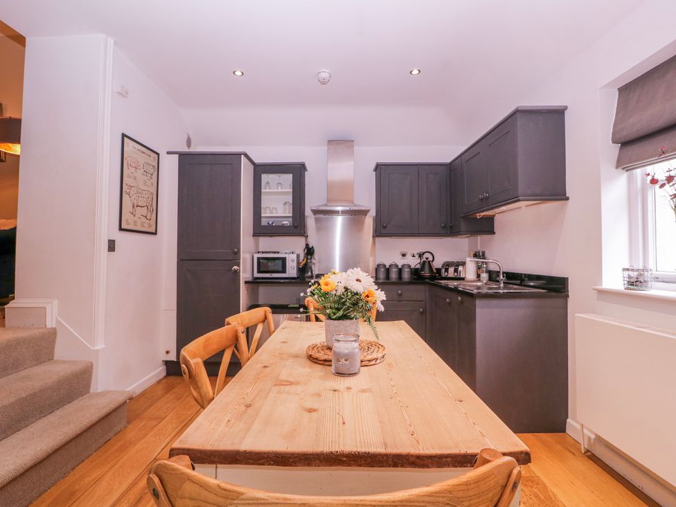 A kitchen with wooden table and chairs at Stylish Town Apartment in Ross-On-Wye