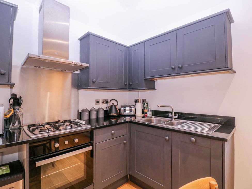 A kitchen with cabinets, gas stove, sink, and appliances at Stylish Town Apartment in Ross-On-Wye