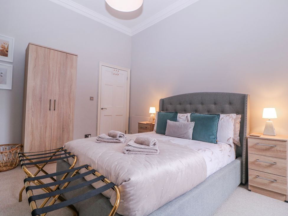 A bedroom with a bed and wardrobe at Stylish Town Apartment in Ross-On-Wye