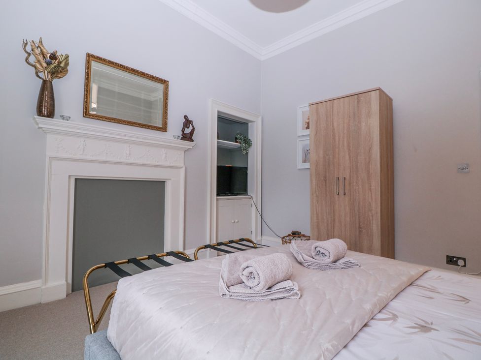 A bedroom with a bed and wardrobe at Stylish Town Apartment in Ross-On-Wye