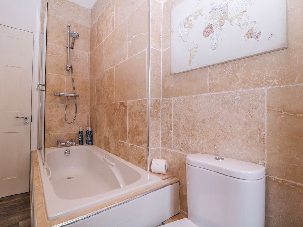 A bathroom with a bathtub and shower at Stylish Town Apartment in Ross-On-Wye