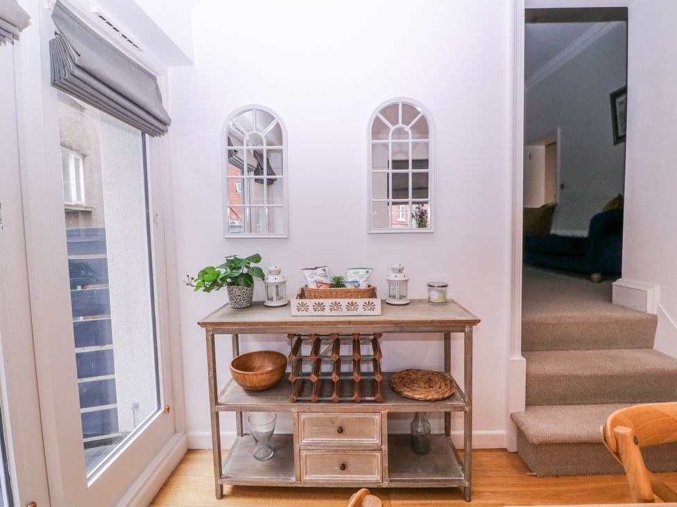 A hallway with a shelf and mirrors at Stylish Town Apartment Ross-On-Wye