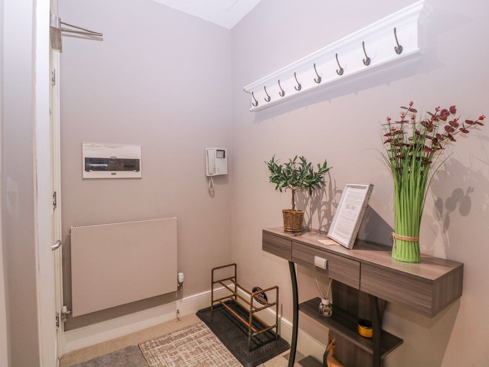 A hallway with coat hooks and a console table at Stylish Town Apartment in Ross-On-Wye