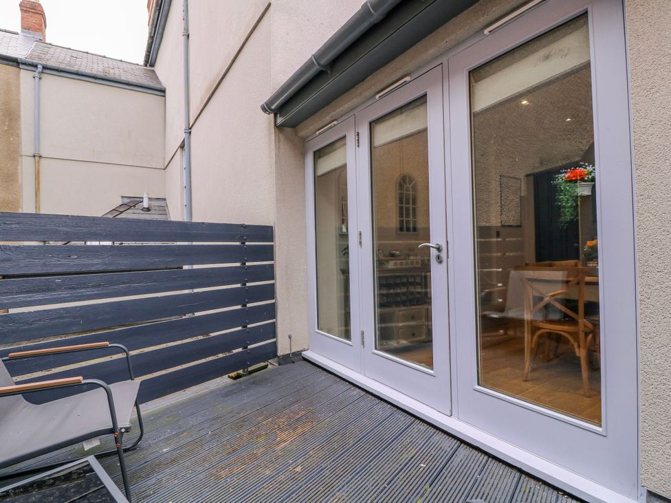 An outdoor area with a deck and sliding doors at Stylish Town Apartment in Ross-On-Wye