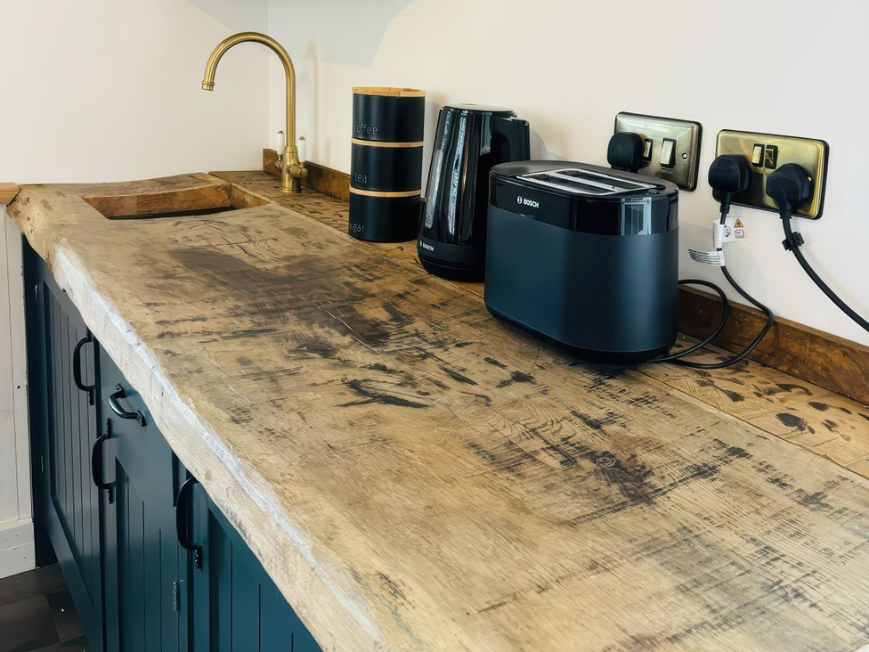 A kitchen with a wooden countertop and appliances at Little Acorn in Whitby