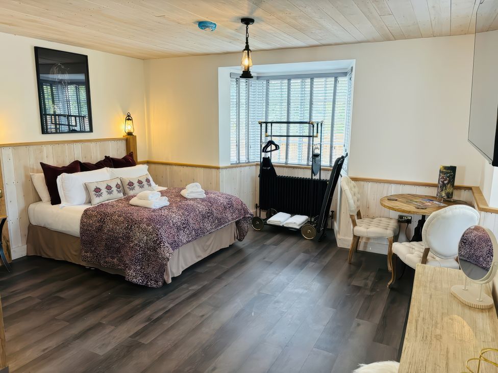 A bedroom with a bed, table, and wardrobe at Little Acorn in Whitby