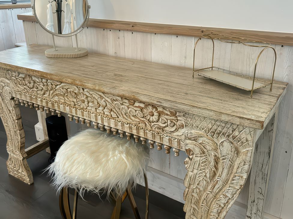 A table with a mirror and a stool at Little Acorn in Whitby