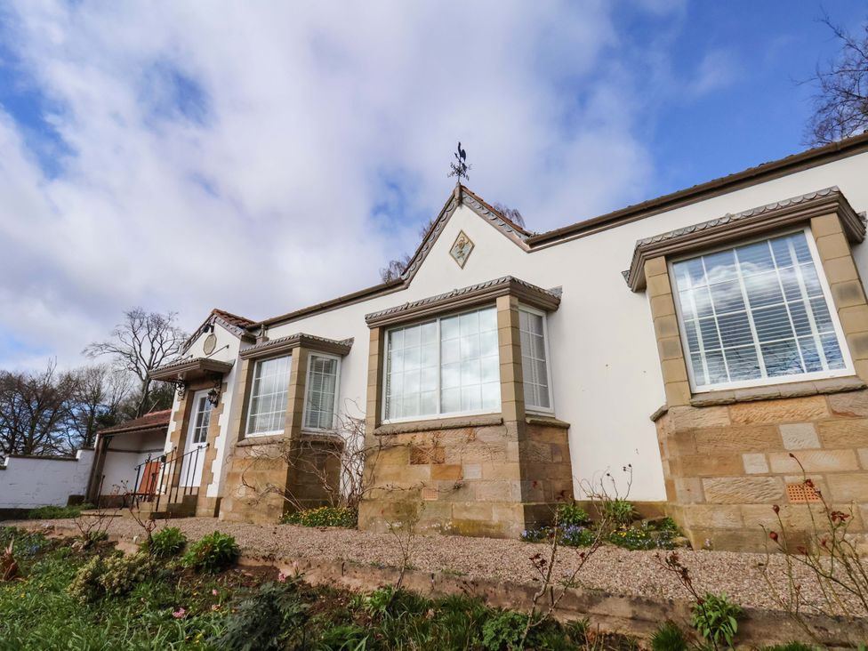 A house with large windows and a stone wall at Hawthorn Lodge in Whitby