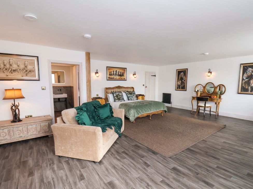 A bedroom with a bed and sofa at Hawthorn Lodge in Whitby