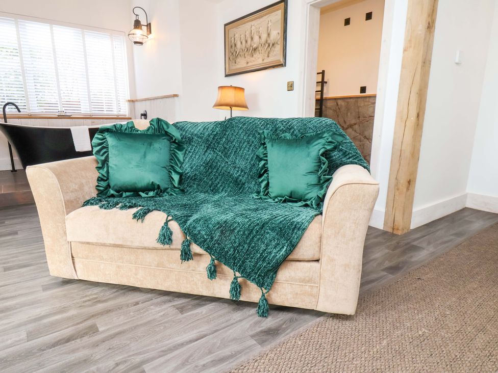 A living room with a sofa and cushions at Hawthorn Lodge in Whitby