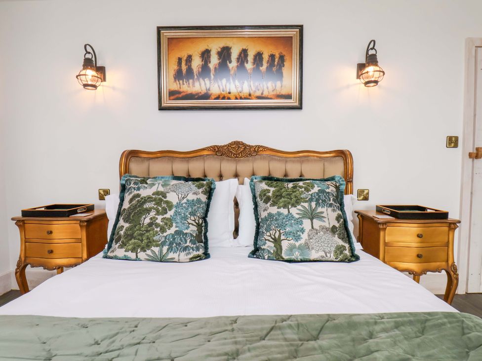 A bedroom with a wooden bed and bedside tables at Hawthorn Lodge in Whitby