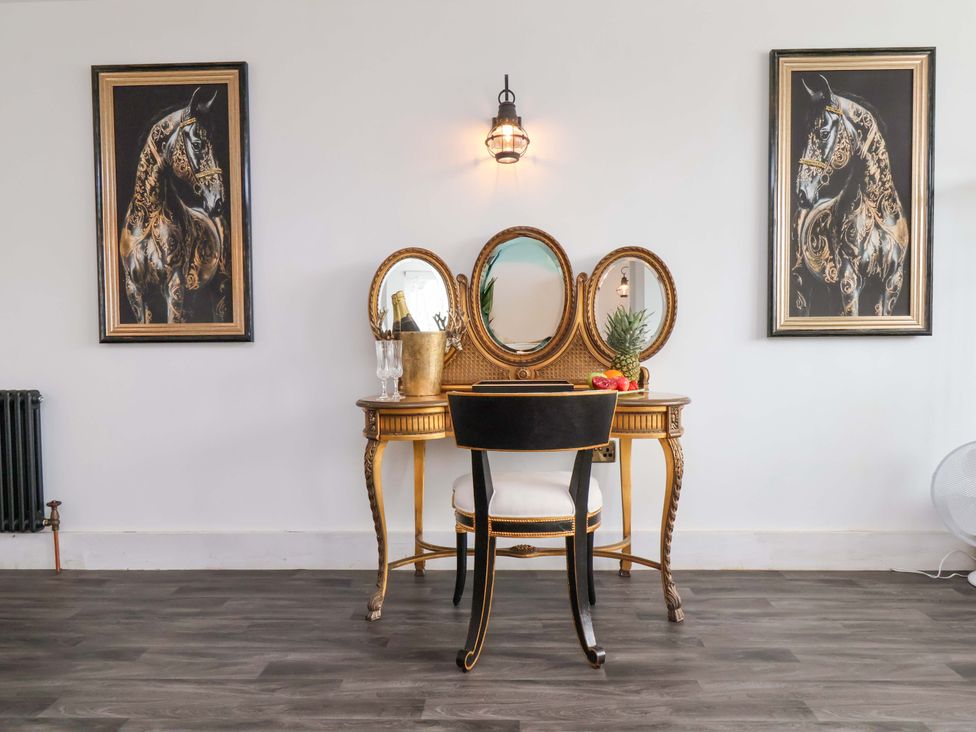 A vanity table with a chair and two wall art pieces at Hawthorn Lodge in Whitby