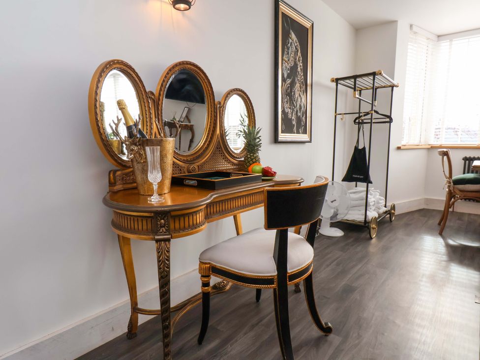 A vanity table with mirrors and a chair at Hawthorn Lodge in Whitby