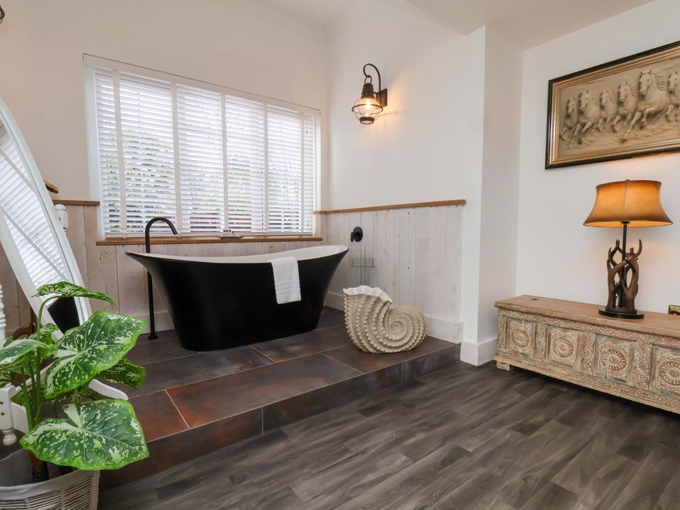 A bathroom with a black bathtub and a plant at Hawthorn Lodge in Whitby