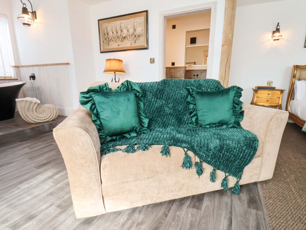 A couch with a throw blanket and cushions at Hawthorn Lodge in Whitby