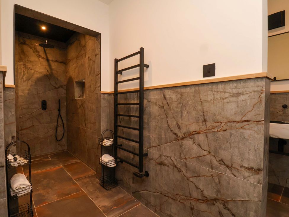 A bathroom with a shower and towel rack at Hawthorn Lodge in Whitby