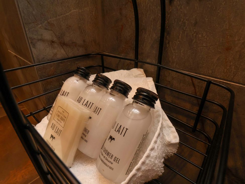 Bottles of body wash and soap on a towel in a basket at Hawthorn Lodge in Whitby
