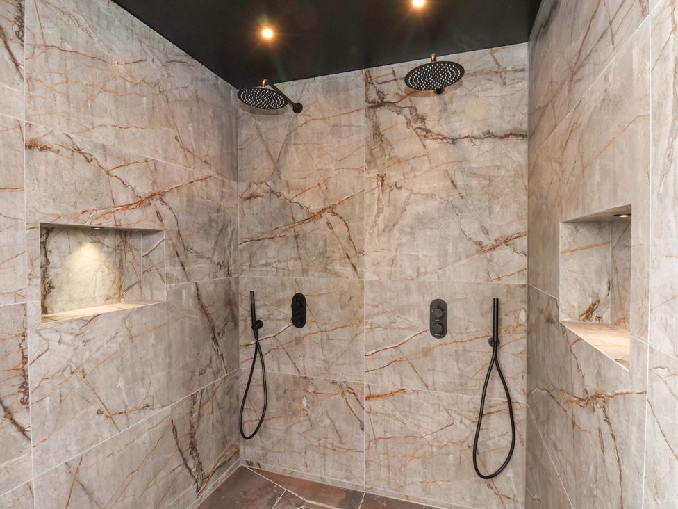 A shower area with two showerheads and niches at Hawthorn Lodge in Whitby