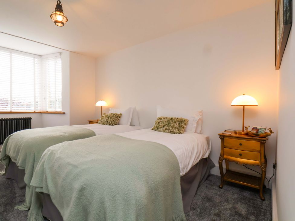A bedroom with two beds and a bedside table at Hawthorn Lodge in Whitby