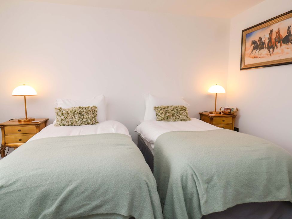 A bedroom with two beds and a nightstand at Hawthorn Lodge in Whitby