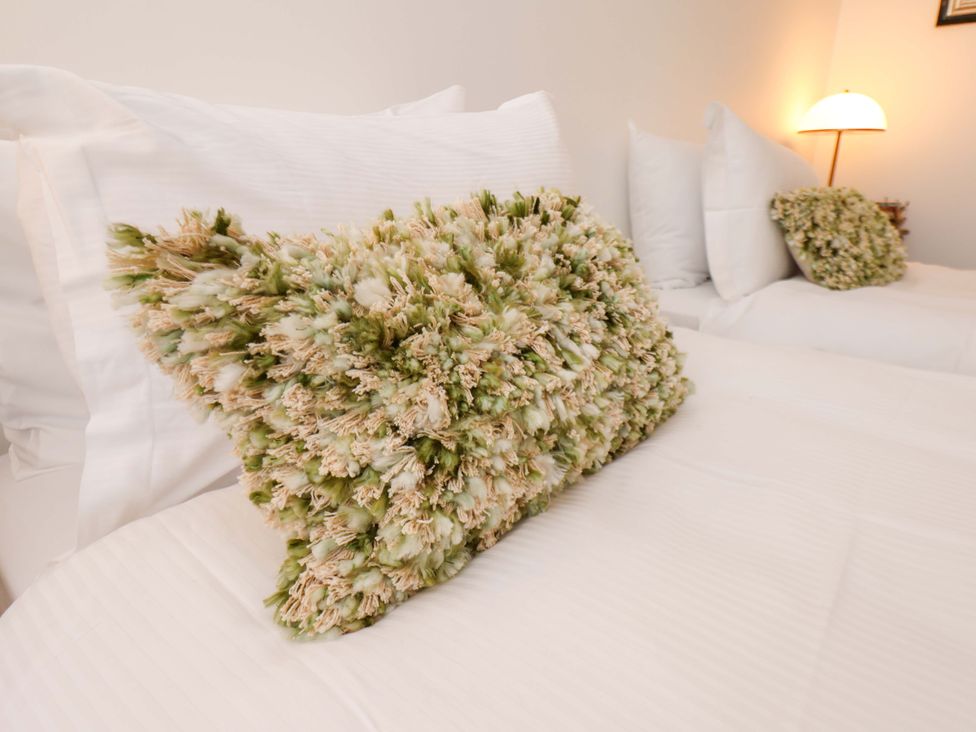 A decorative pillow on a bed at Hawthorn Lodge in Whitby