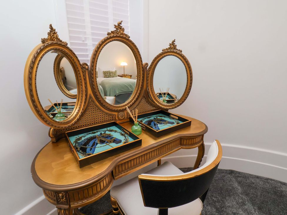 A dressing table with mirrors and decorative trays in a bedroom at Hawthorn Lodge in Whitby