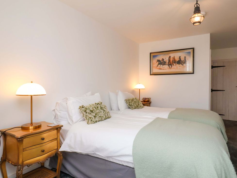 A bedroom with twin beds and a bedside table at Hawthorn Lodge in Whitby