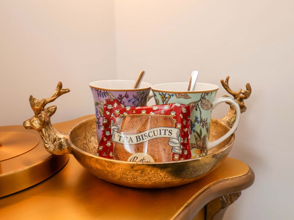 A bowl with mugs and a biscuit packet at Hawthorn Lodge in Whitby