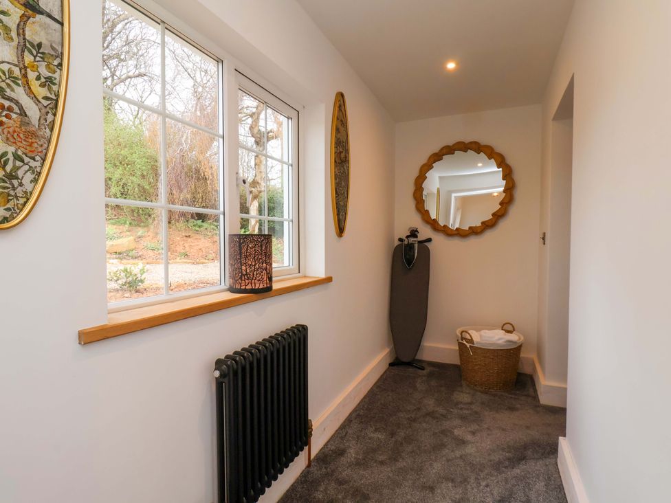A hallway with windows and a mirror at Hawthorn Lodge in Whitby