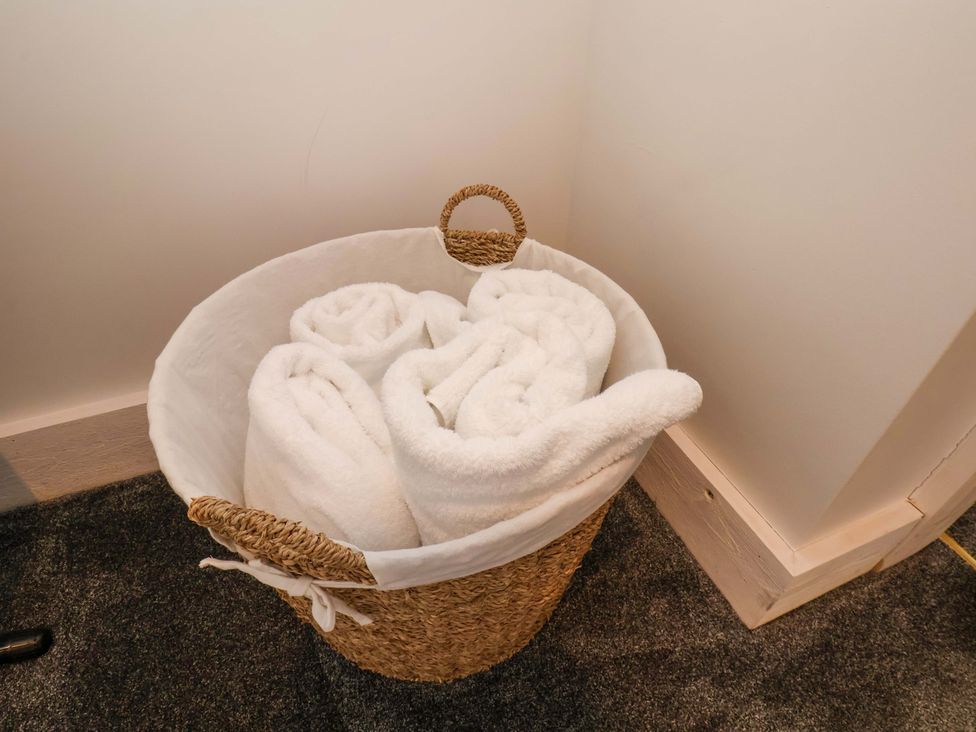 A basket with rolled towels in a bathroom at Hawthorn Lodge in Whitby