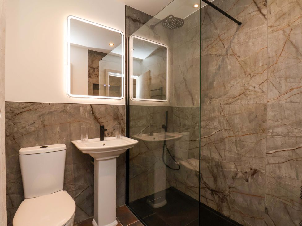 A bathroom with a toilet, sink, and shower at Hawthorn Lodge in Whitby