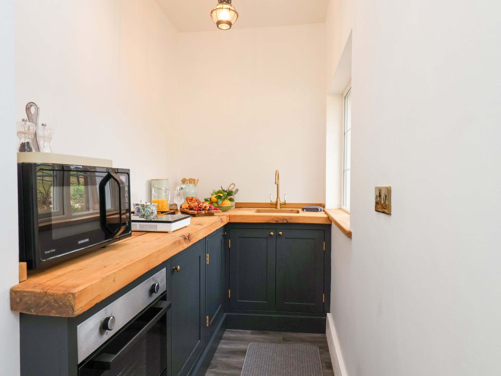 A kitchen with a sink, microwave, and oven at Hawthorn Lodge in Whitby