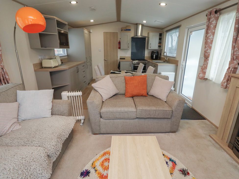 A living room with contemporary furniture and kitchen units at Cresswell Towers